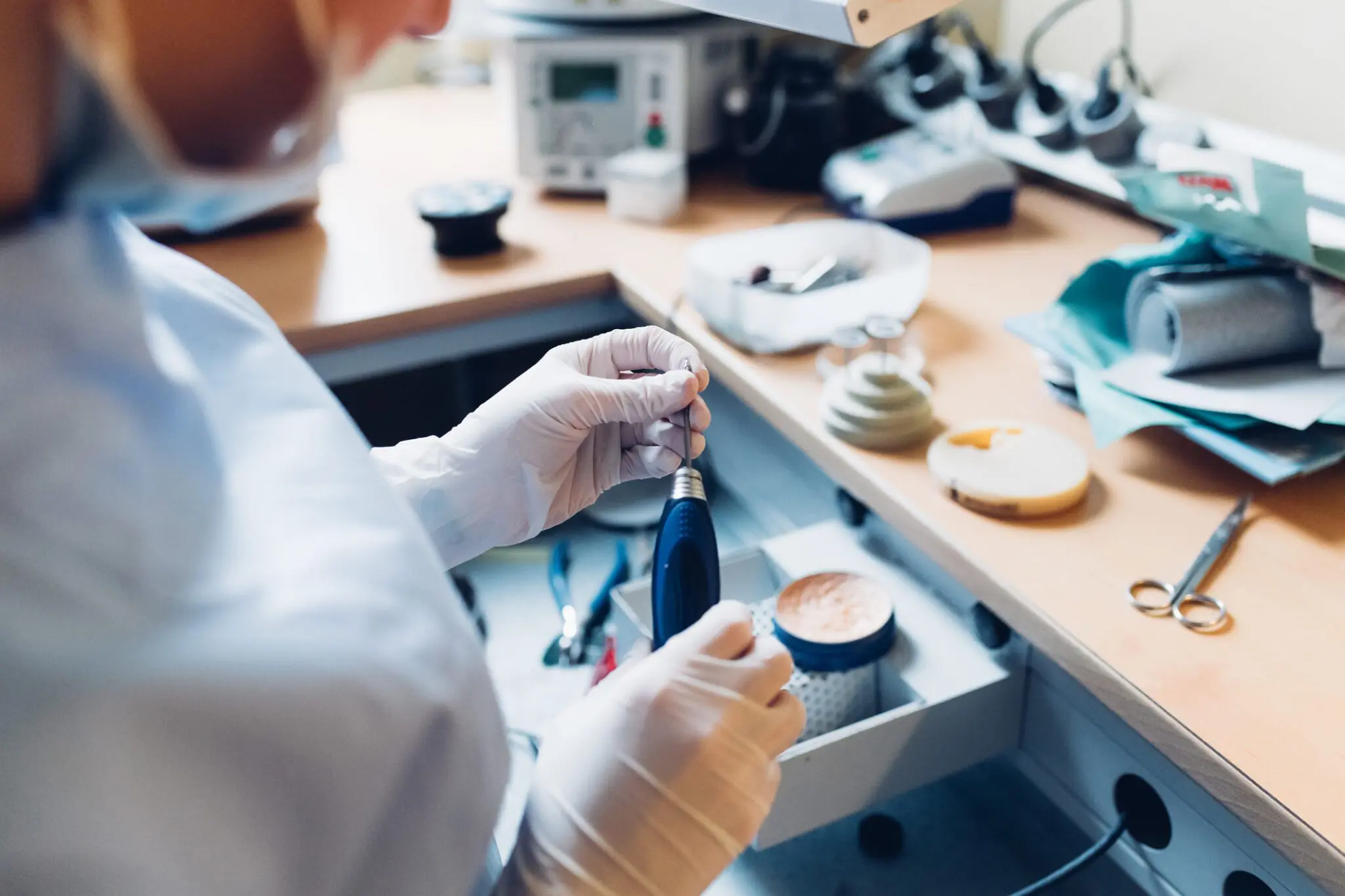 Female dentist handling dentistry equipment in dentist office, mid section