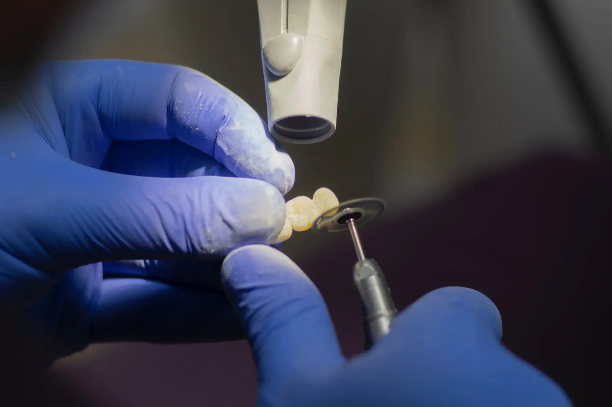 dental lab technician working on a dental bridge